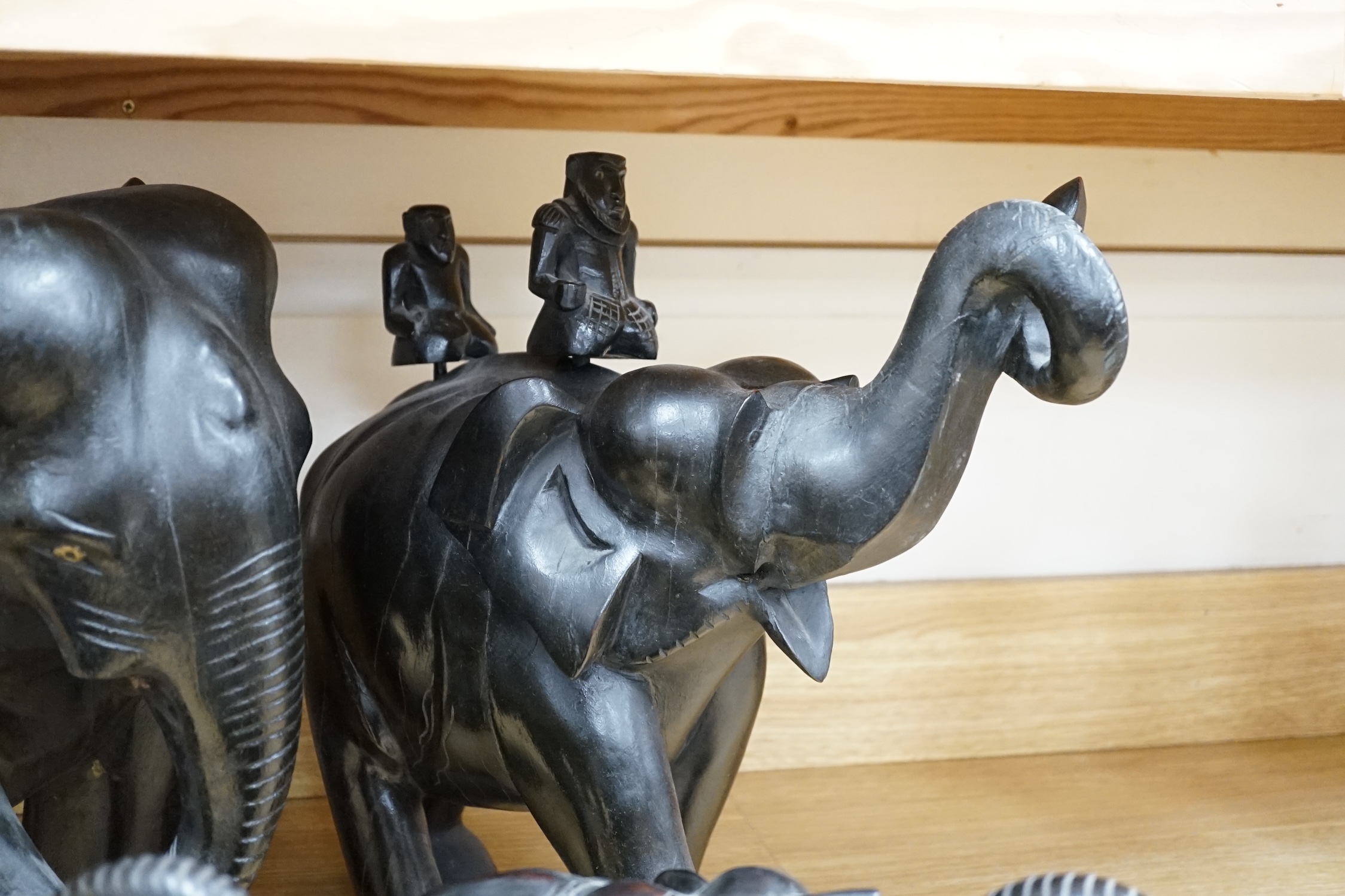 Two large carved ebony elephants and two smaller similar elephants